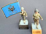 two figurines of two soldiers with a flag and a flagpole