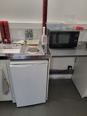 une petite cuisine équipée d'un micro-ondes, d'un lave-vaisselle, d'un lave-vaisselle et d'un lave-vaisselle