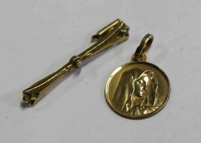 un gros plan sur une médaille et un pin's posés sur une surface blanche