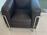 un fauteuil en cuir noir placé devant une porte vitrée
