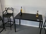three chairs and a table with a bottle of wine on it