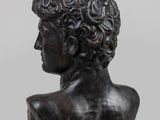 a bronze bust of a young man with curly hair