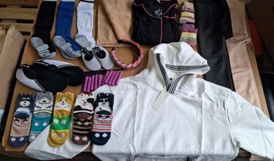 many pairs of socks and clothes laid out in a suitcase