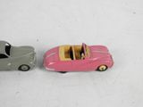 two toy cars sitting next to each other on a white surface