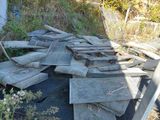 a pile of wood sitting on the ground next to a fence