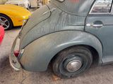 an old car parked in a garage with other cars