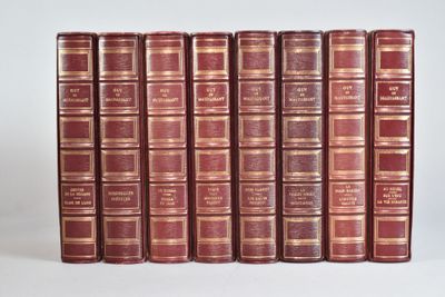 plusieurs vieux livres sont alignés sur une surface blanche