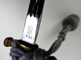 a close up of a knife with a rope attached to it