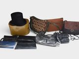 many different purses and wallets laid out on a table