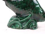 a green fish figurine sitting on top of a table