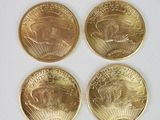 quatre pièces d'or superposées sur une surface blanche