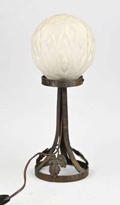 une photo d'une lampe de table sur laquelle repose une boule en verre blanc