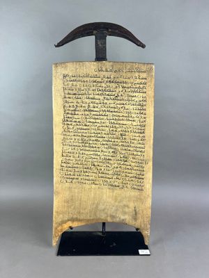un vieux document posé sur un support muni d'une poignée en bois