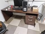 a desk with a computer on top of it in a room