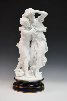 figurine en porcelaine blanche représentant deux femmes se tenant la main, posée sur un socle noir