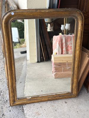 a mirror that is sitting on the ground next to a pile of boxes