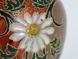a vase with a floral design on it sitting on a table