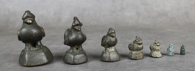 cinq figurines de tailles et de formes différentes posées sur une table