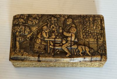 un gros plan sur une boîte posée sur une table, avec un chien à côté