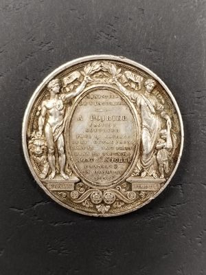 un gros plan d'une pièce d'argent sur laquelle est apposée une plaque