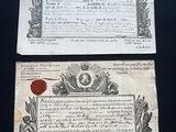 two old papers on a table with a wax seal and a wax seal