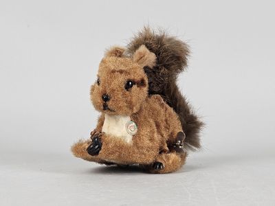 a small stuffed squirrel that is sitting on the ground