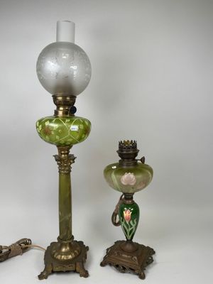 deux lampes en verre vert posées l'une à côté de l'autre sur une surface blanche