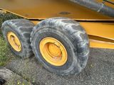 two large tires on the back of a yellow truck
