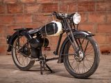 a black and white motorcycle parked in front of a brick wall