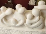 a white sculpture of a group of people on a table