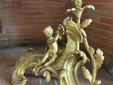 a gold statue on a brick floor next to a brick wall