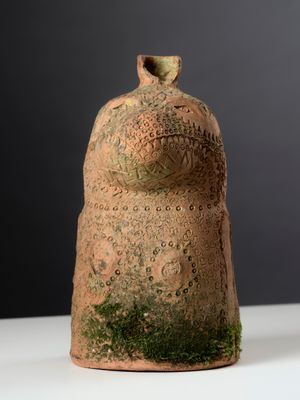 a small vase with moss growing on it on a table