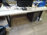 a desk with a computer monitor and a trash can on it