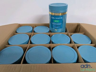 une boîte en carton remplie de bocaux bleus et d'un bidon