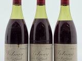 trois bouteilles de vin sont alignées sur une surface blanche