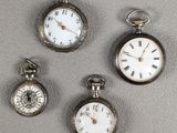 Quatre types différents de montres de poche sont exposés sur une table