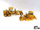 deux engins de chantier miniatures posés l'un à côté de l'autre