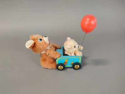 two teddy bears in a toy car with a red balloon