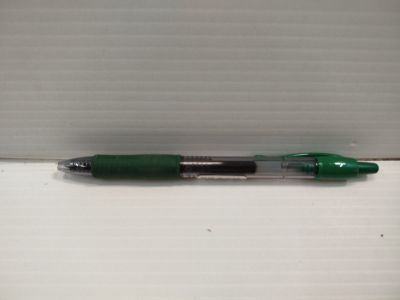 un stylo vert posé sur une surface blanche
