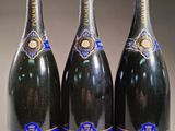 trois bouteilles de champagne sont alignées sur une table