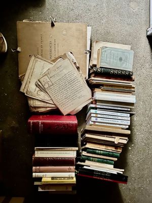 une pile de livres posée par terre à côté d'un ordinateur portable