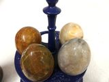 a blue vase filled with marbles on top of a table