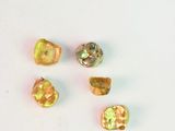 quatre perles de verre de couleur jaune et verte sur un fond blanc