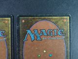 two decks of magic the gathering are shown on a black surface