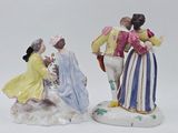 two figurines of people are standing next to each other