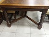 a wooden table with two chairs in the corner of the room