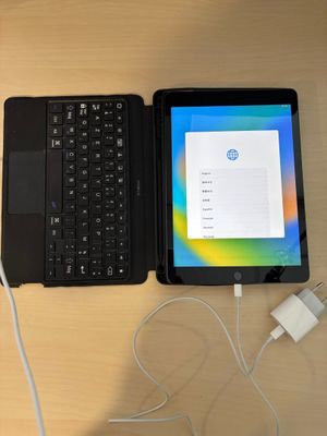 un ordinateur portable et une tablette posés sur une table avec un chargeur