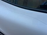 un gros plan d'une voiture blanche dont la vitre est fissurée