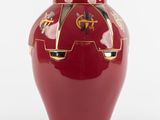 un vase rouge orné d'un motif doré