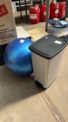 a trash can and a blue ball on the floor